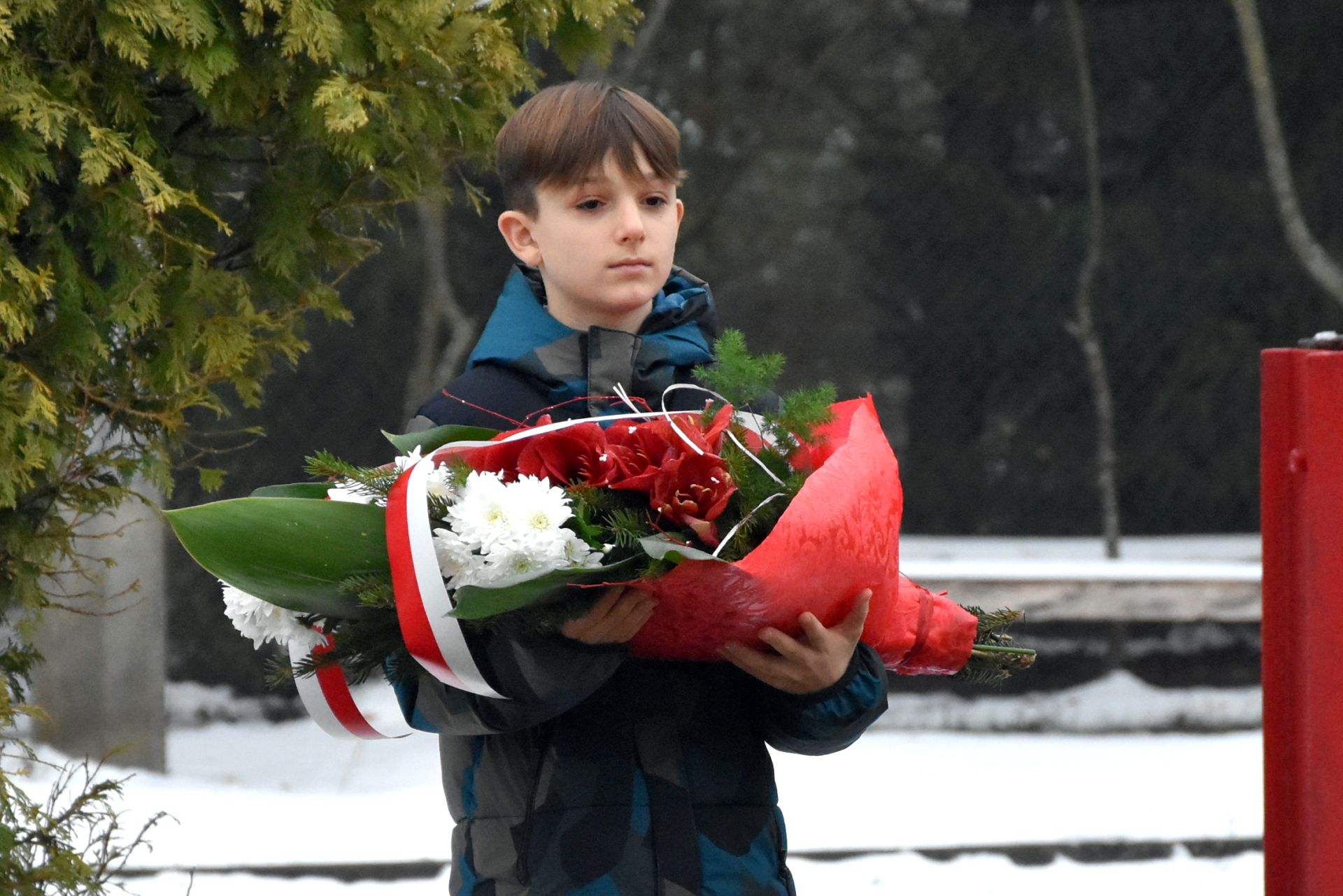 Spotkanie pn. "Śniadanie z Marszałkiem" w Szkole Podstawowej im. Marszałka Józefa Piłsudskiego w Rogóżu - uczeń trzymający kwiaty